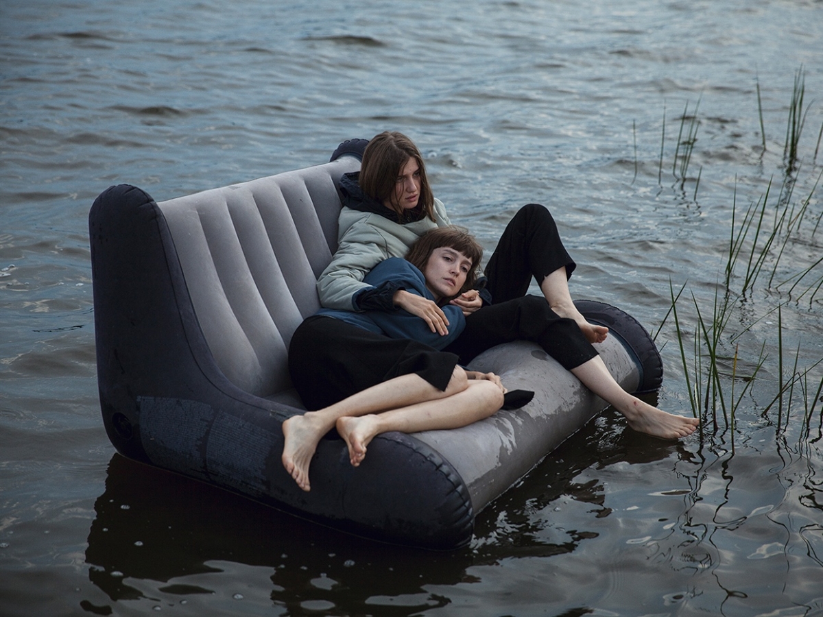 zwei Frauen treiben auf einem Sofa durch das Wasser Foto von Masha Demianova