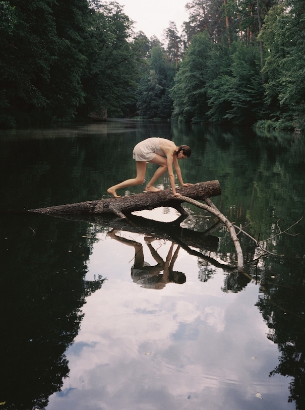 Masha Demianova Fotografie Frau klettert im Fluss über Baum