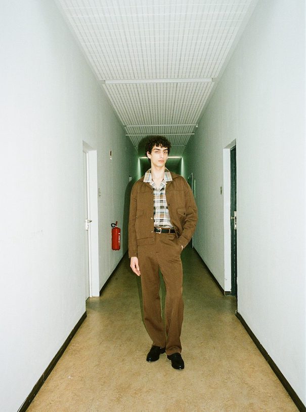 Sissi Goetze Model Brown suit standing hallway campaign