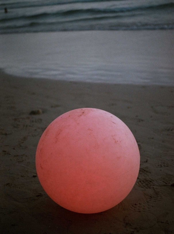 Pinker Ball am Strand mit Meer fotografiert von Wirktor Malinowski