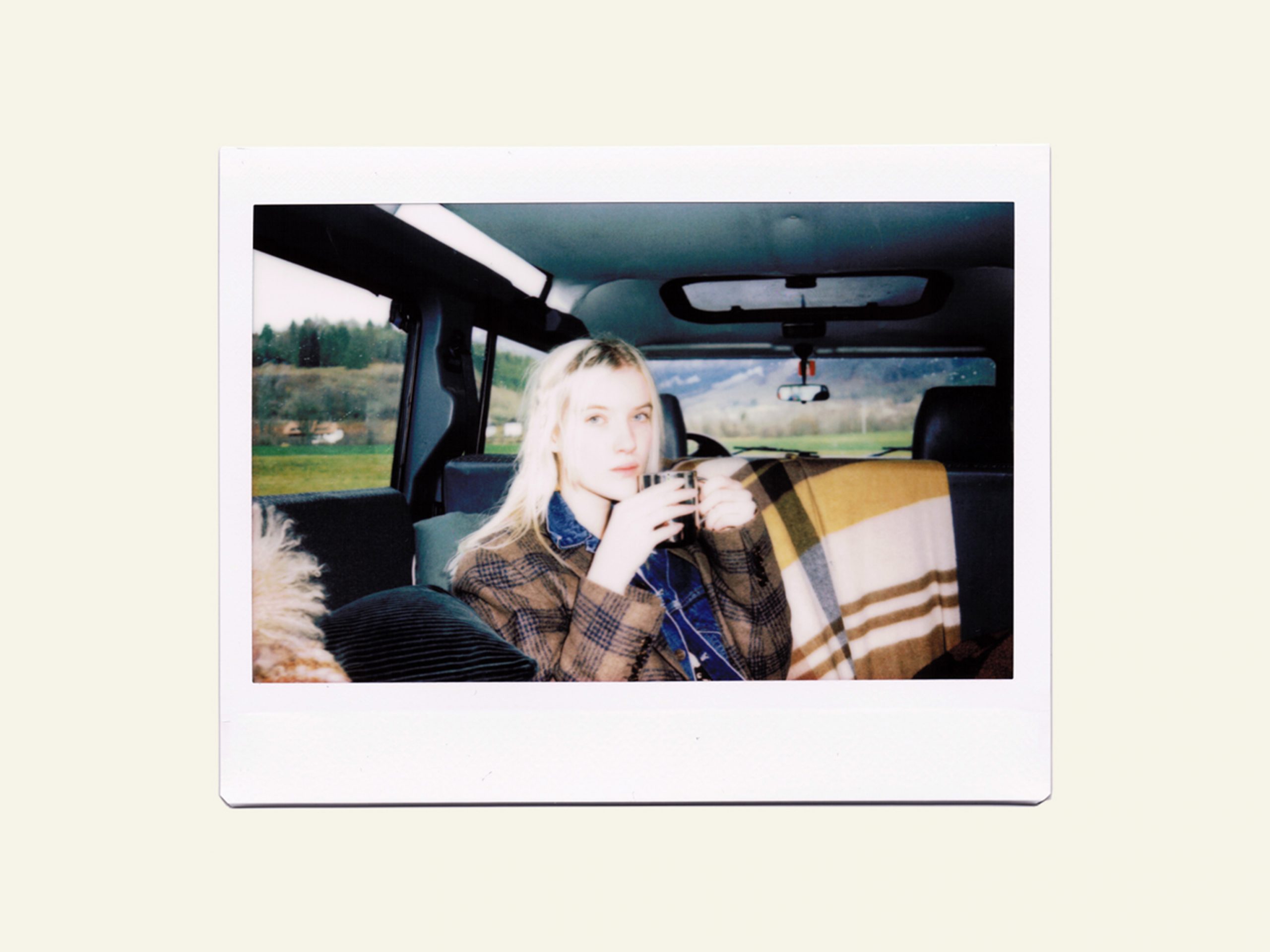 Van Life Feli in Brunello Cucinelli jacket with hot tea in Defender Jeep