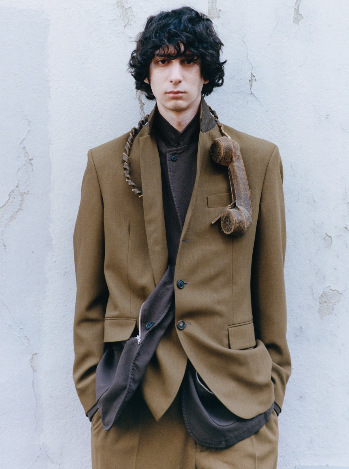 Male model wearing Suit TOD’S; Jacket COMME DES GARÇONS SHIRT; Phone accessory GAL NELL DAHAN