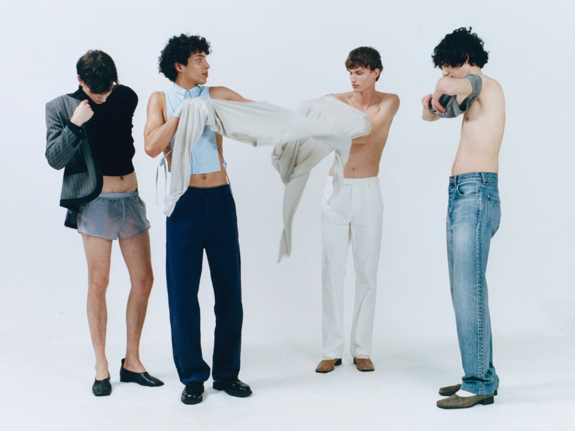 Four male models dressing for ACHTUNG 51 behind the scenes shoot